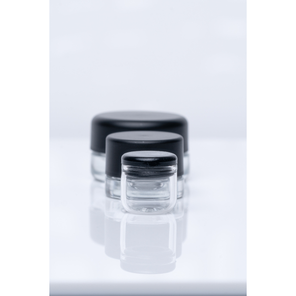 Three glass jars with black lids are displayed on a reflective white surface. The jar in the back is the largest, holding 9ml, followed by a medium-sized jar in the center 5 ml, and a small jar in the front 6 ml. Washington, Oregon, Northwest, West Coast